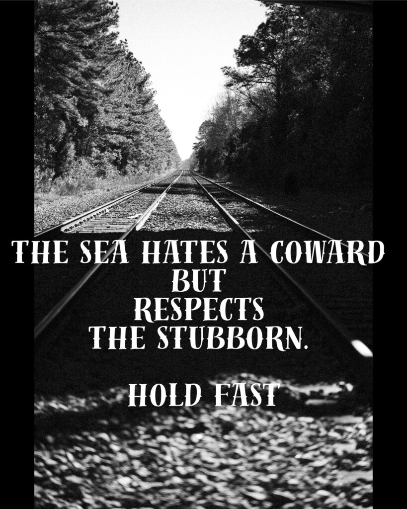 A high-contrast, black and white photograph of railroad tracks receding into a distant horizon lined with trees. Overlaid text in a weathered, nautical-style serif font reads: 'THE SEA HATES A COWARD BUT RESPECTS THE STUBBORN. HOLD FAST.'