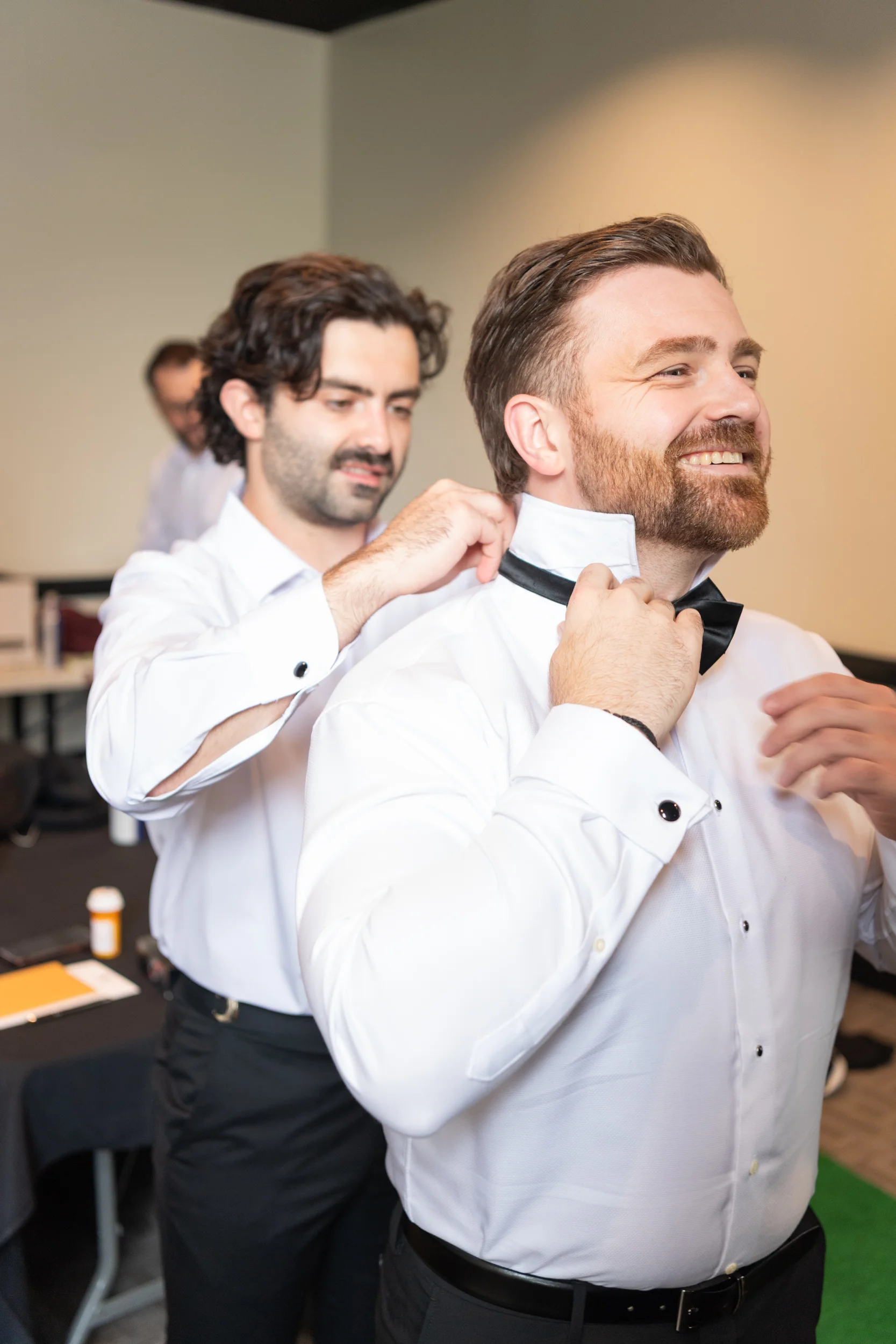 Groom & groomsmen helping groom put bowtie on in Charlotte, NC